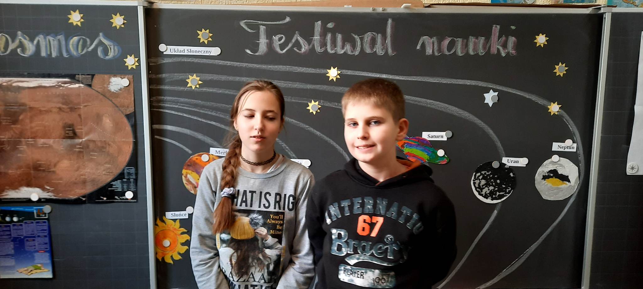 Dwie osoby stoją przy tablicy