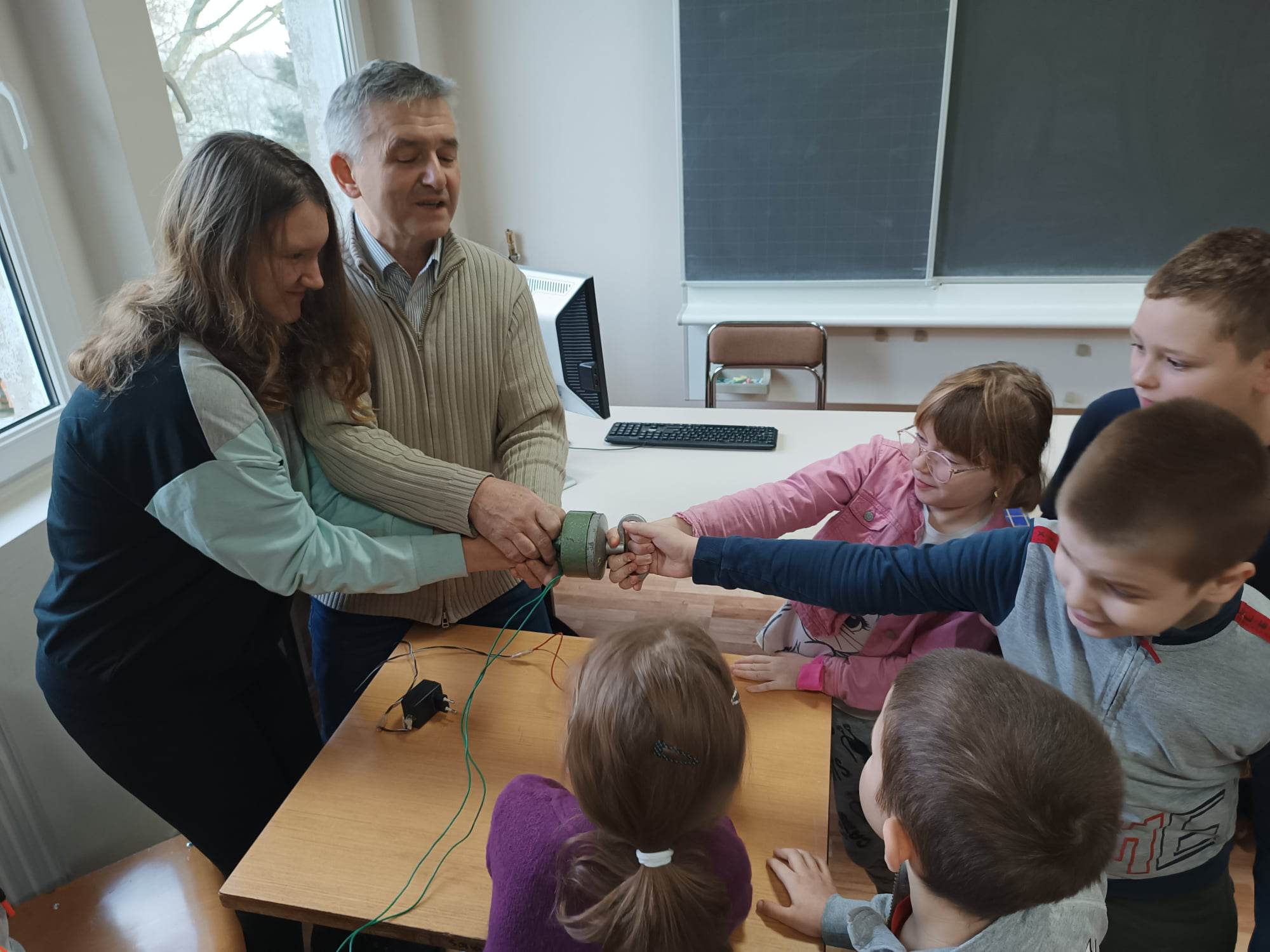 Grupa osób stoi przy stoliku