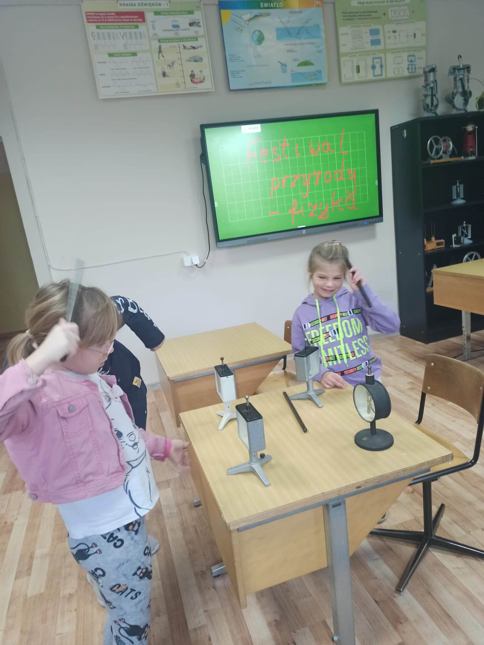 Grupa osób stoi przy stoliku 