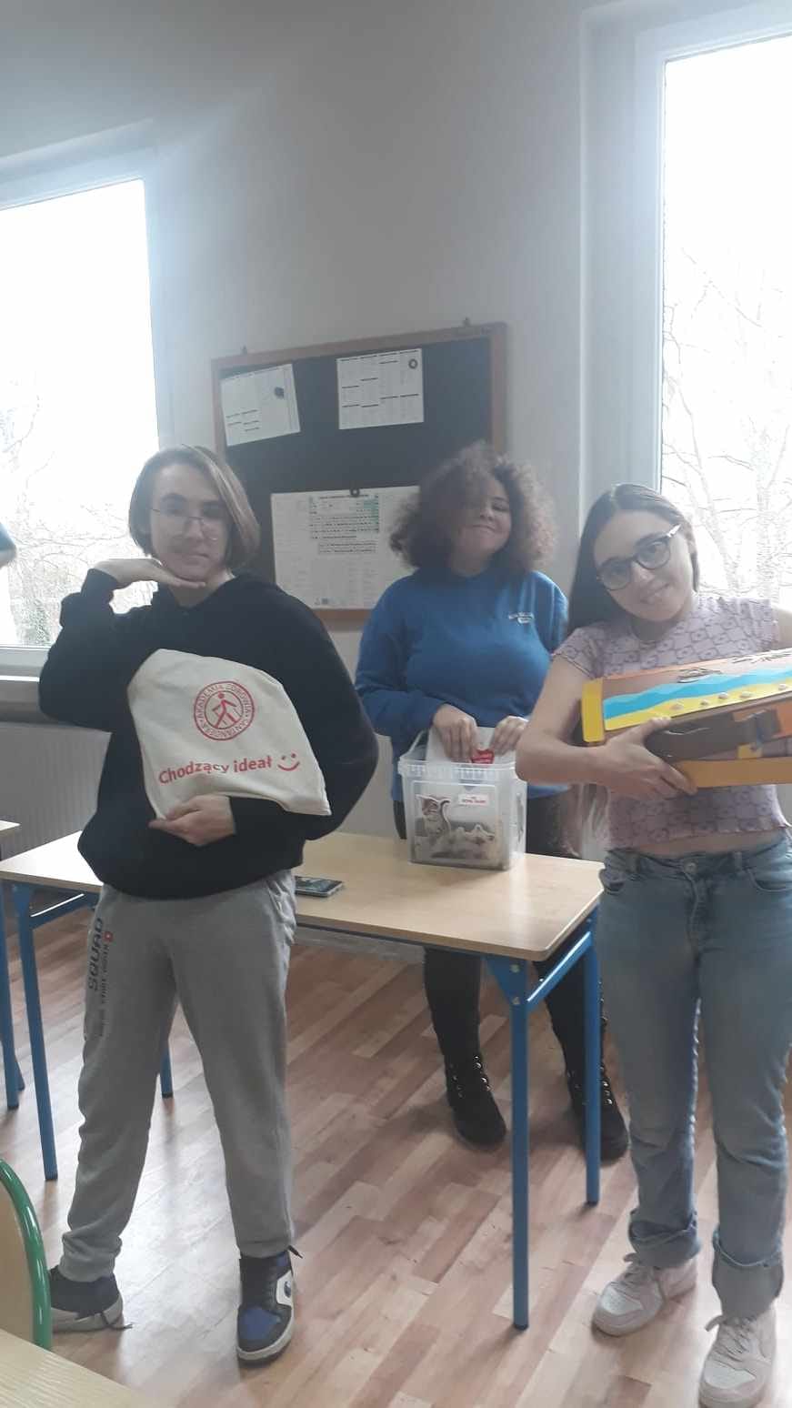W pomieszczeniu pod oknem stoi grupa osób