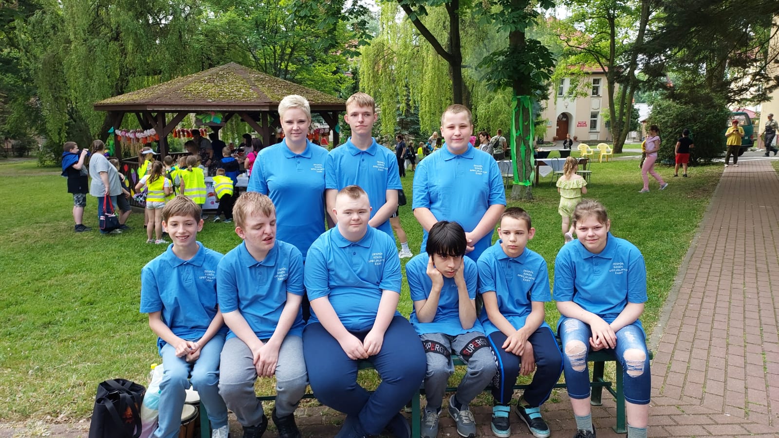 Na środku znajduje się grupa osób