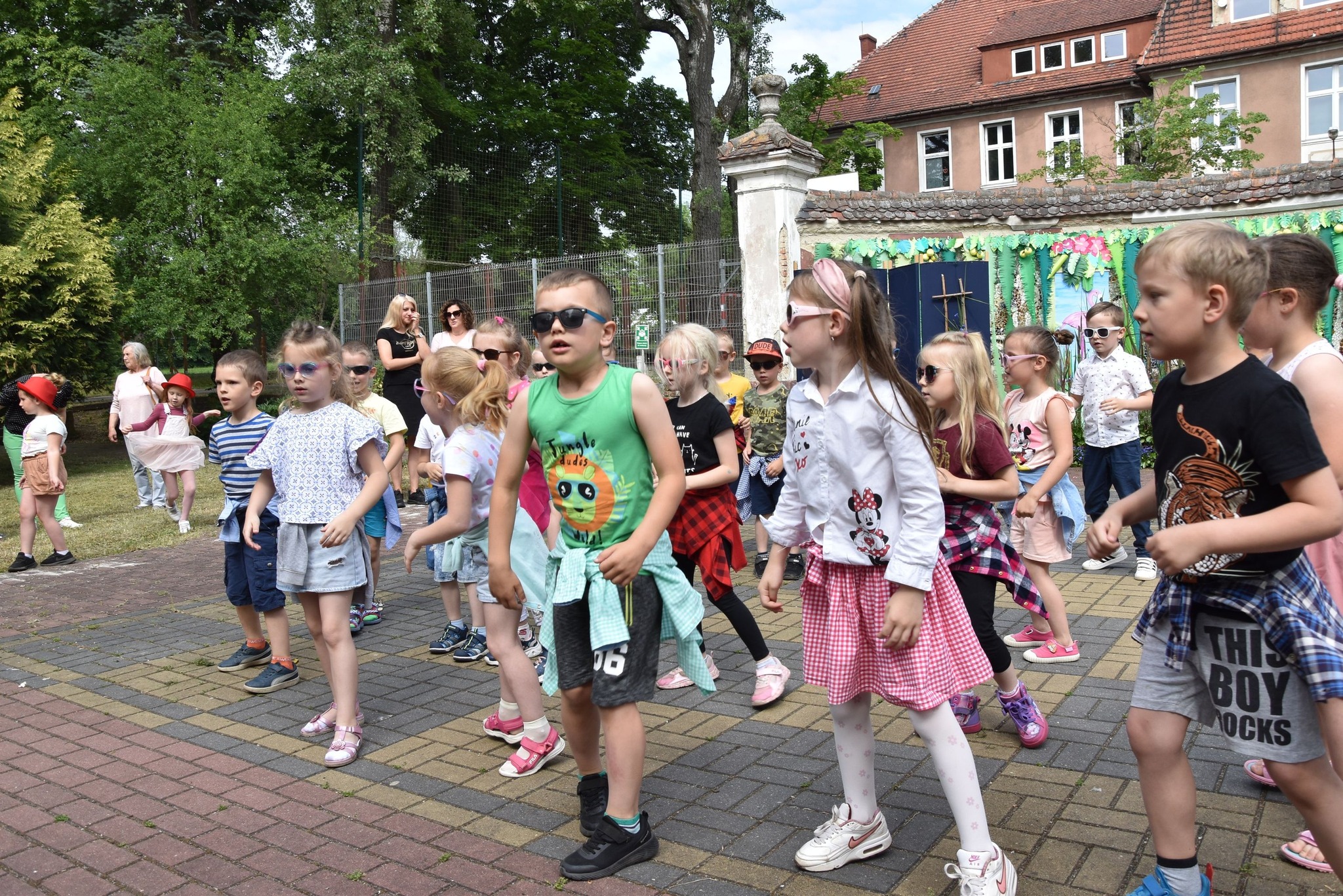 Na środku znajduje się grupa osób