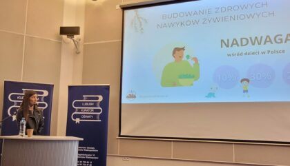 W pomieszczeniu na ścianie wyświetlana jest prezentacja 