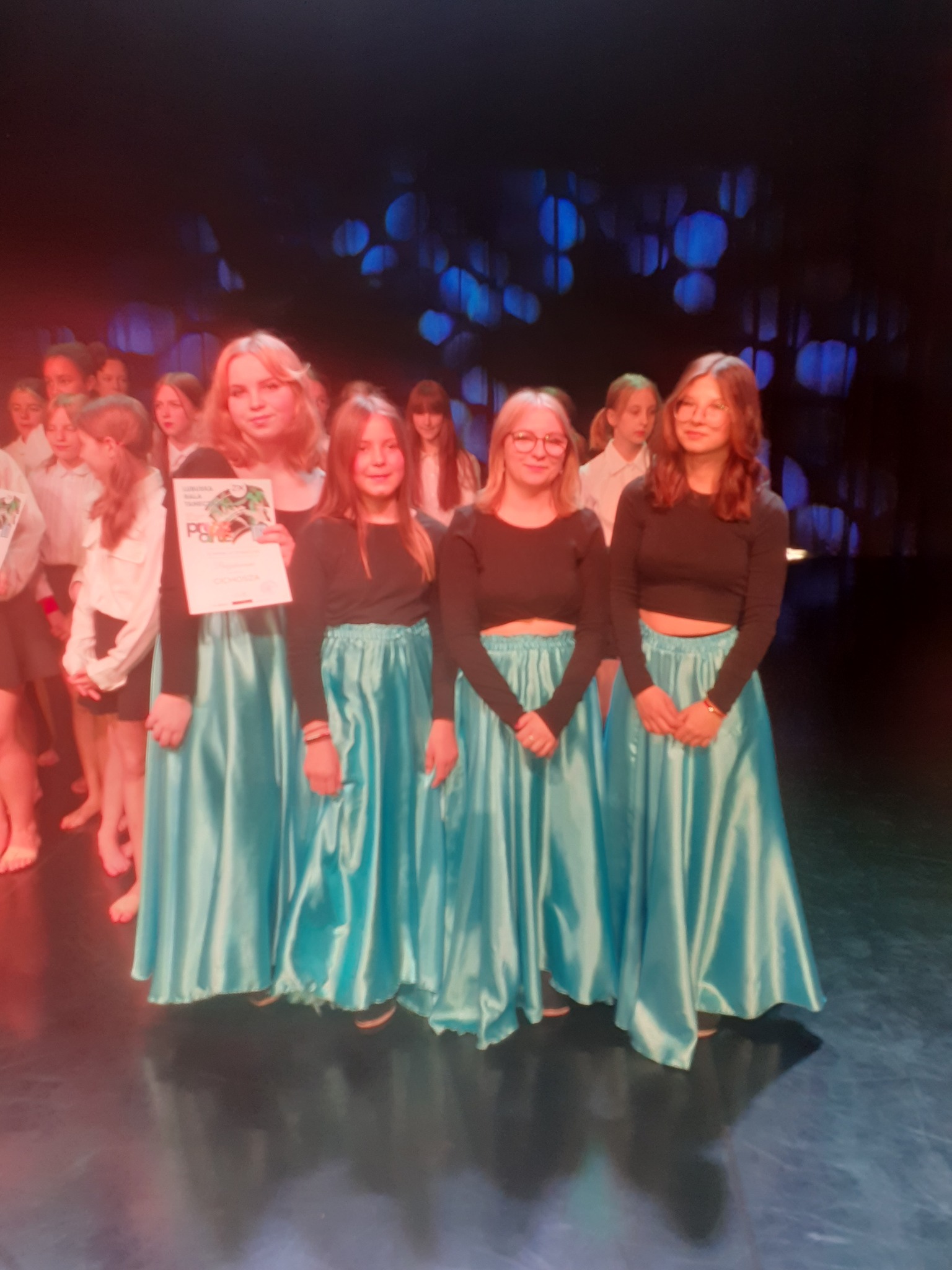 Na środku stoi grupa osób