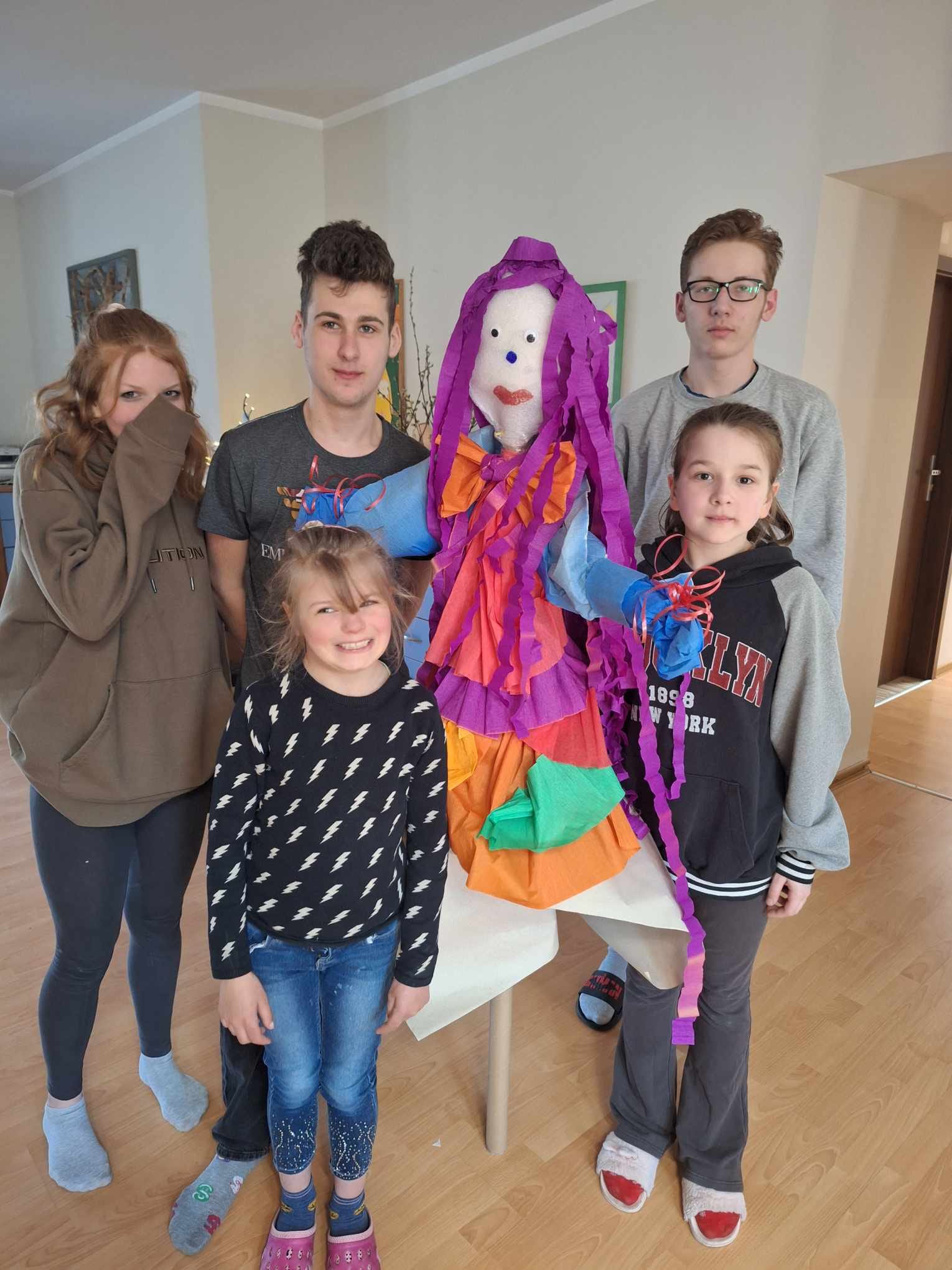 W pomieszczeniu stoi grupa osób