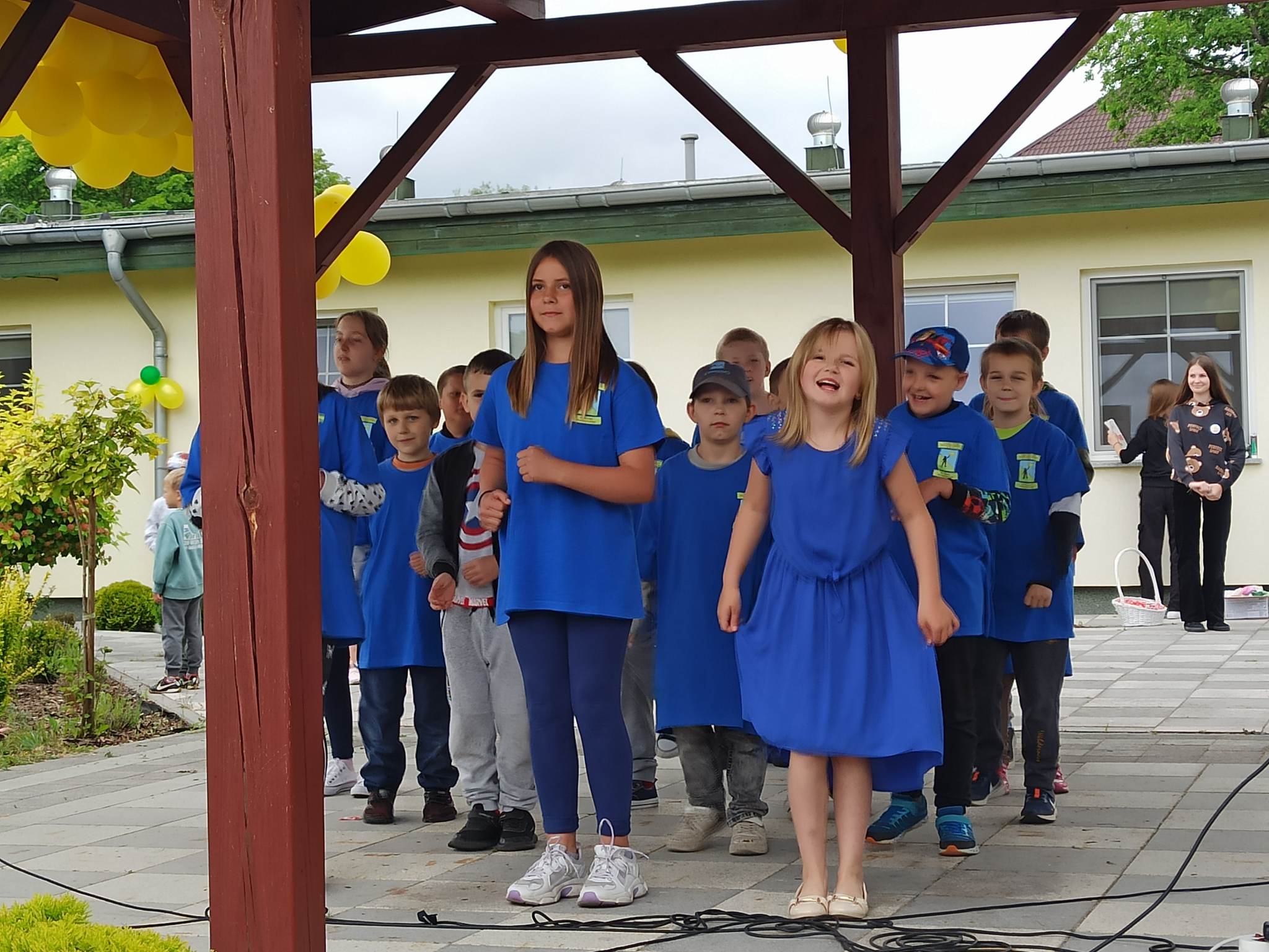 Na środku znajduje się grupa osób