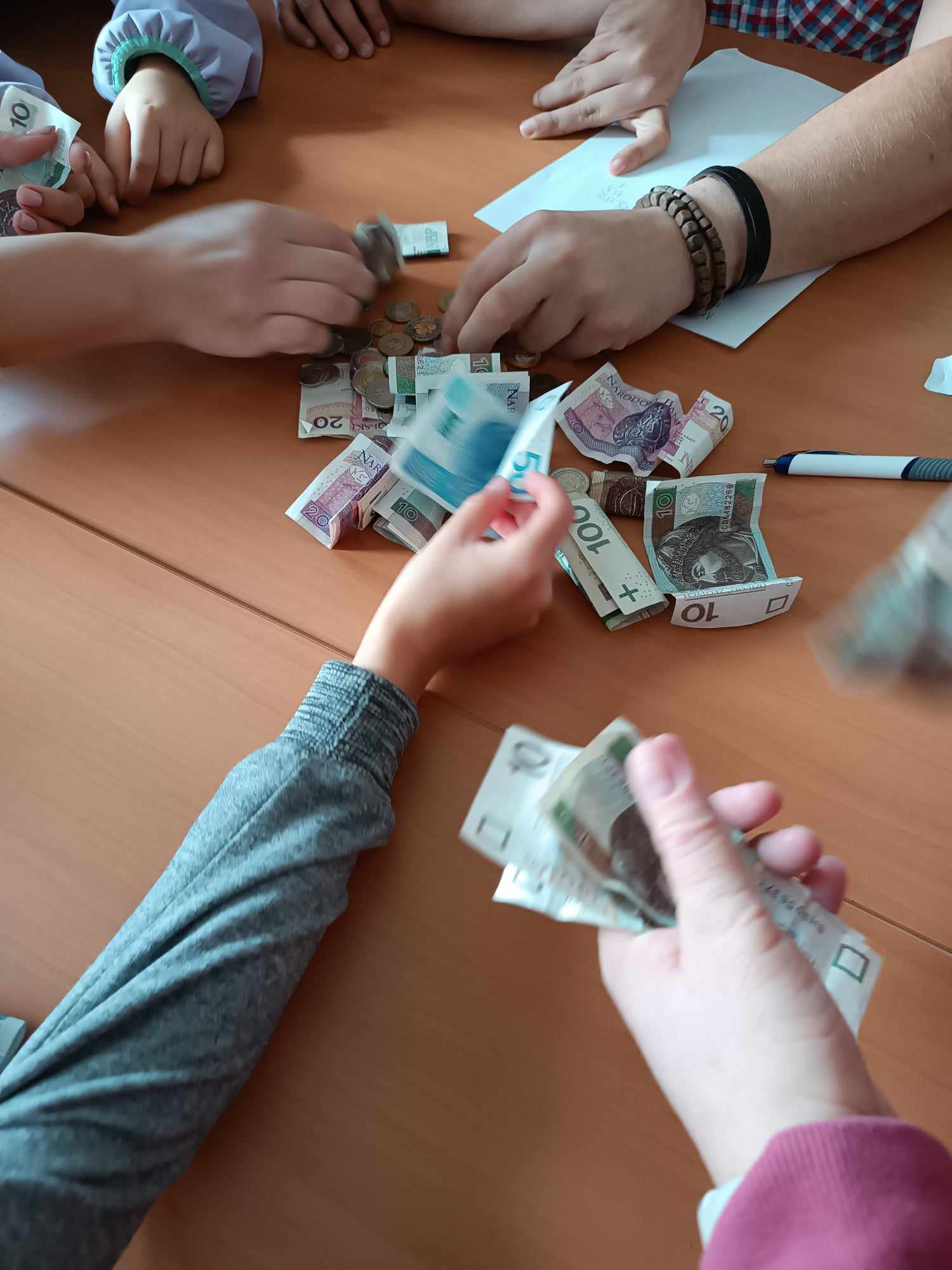 Na stole leżą pieniądze i widać rece