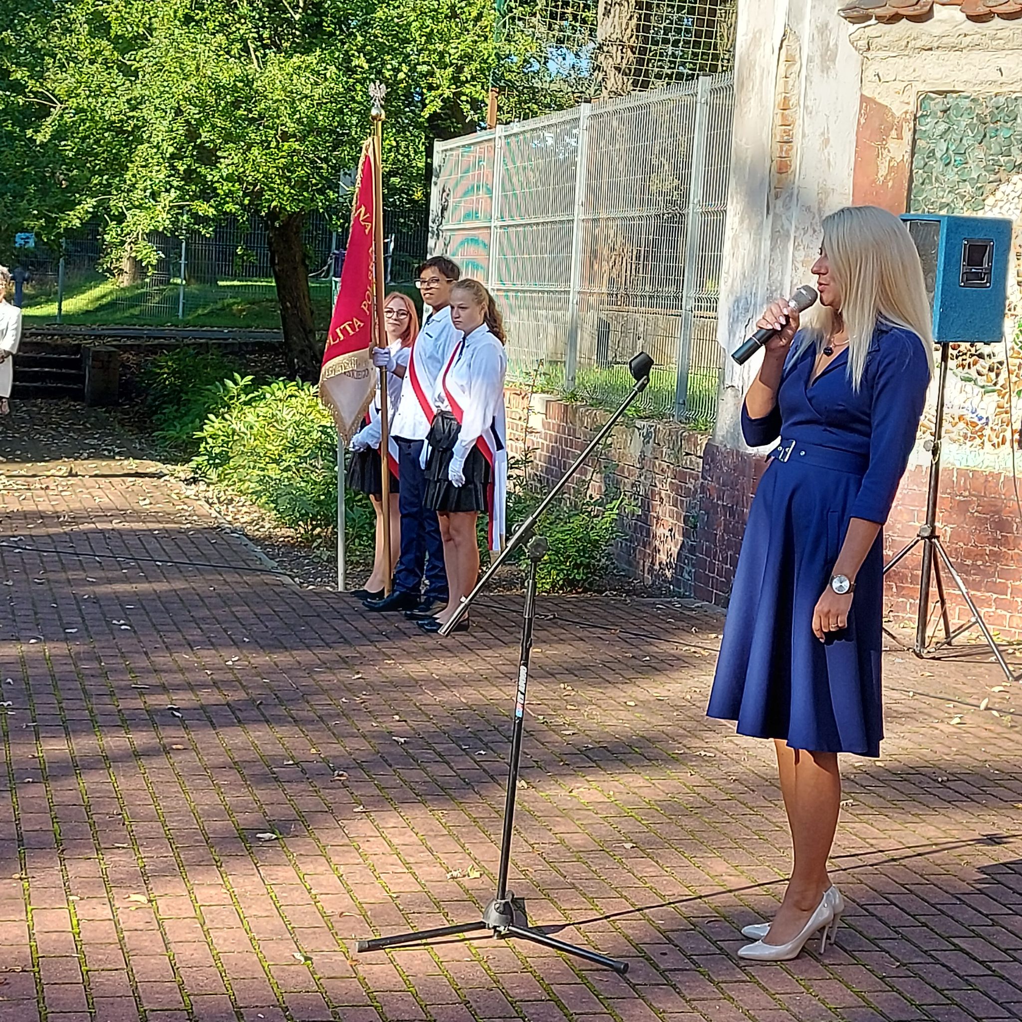 Na środku stoi grupa osób