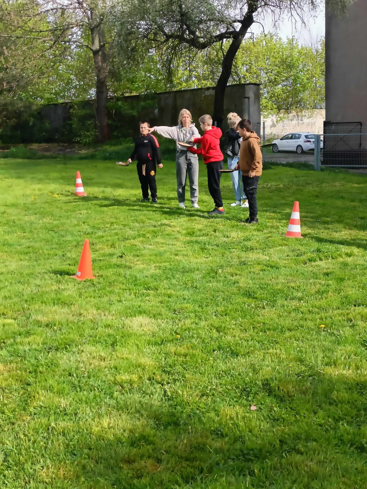 Na trawniku stoi grupa osób 