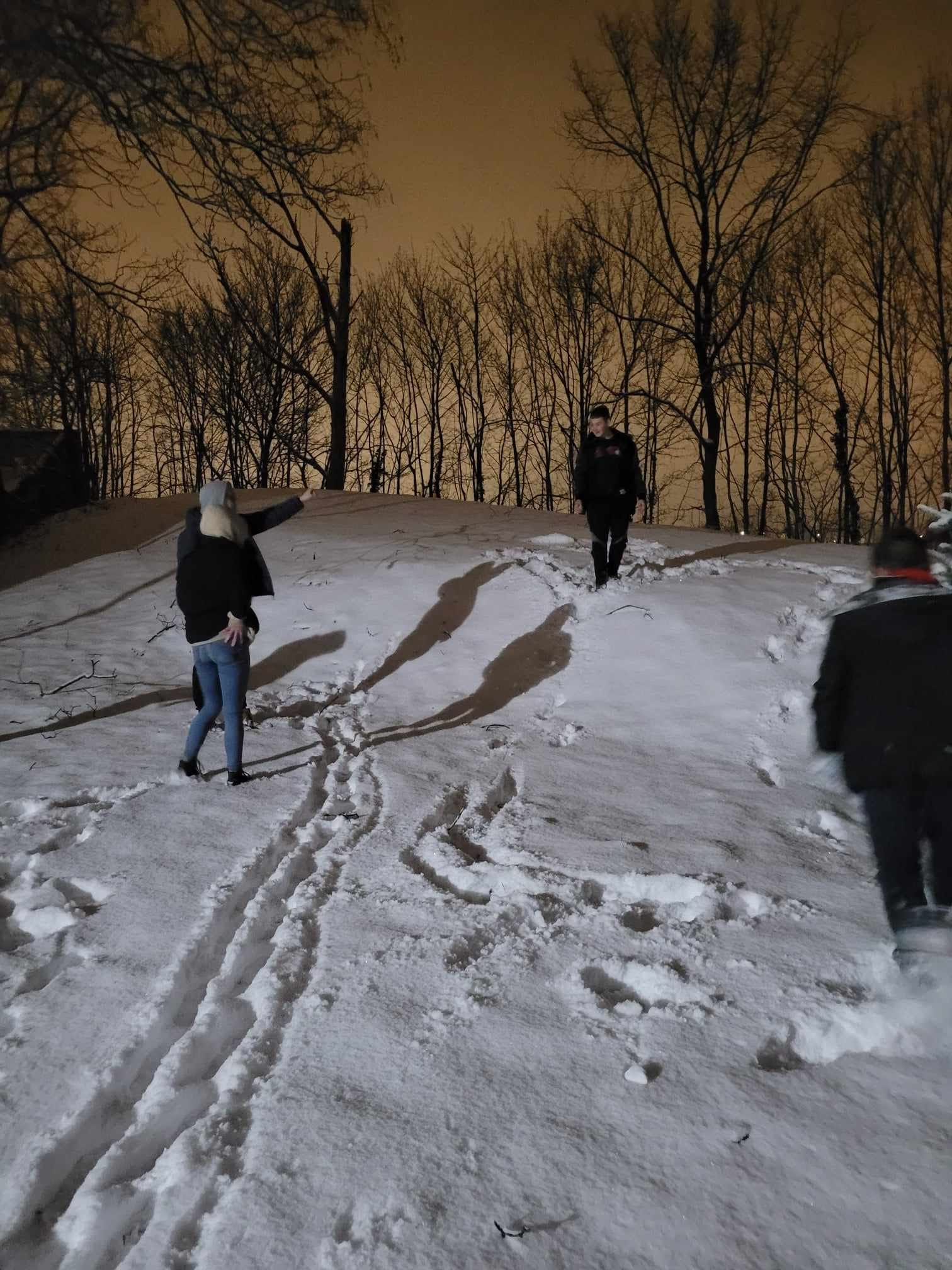 Na śniegu znajduje się grupa osób