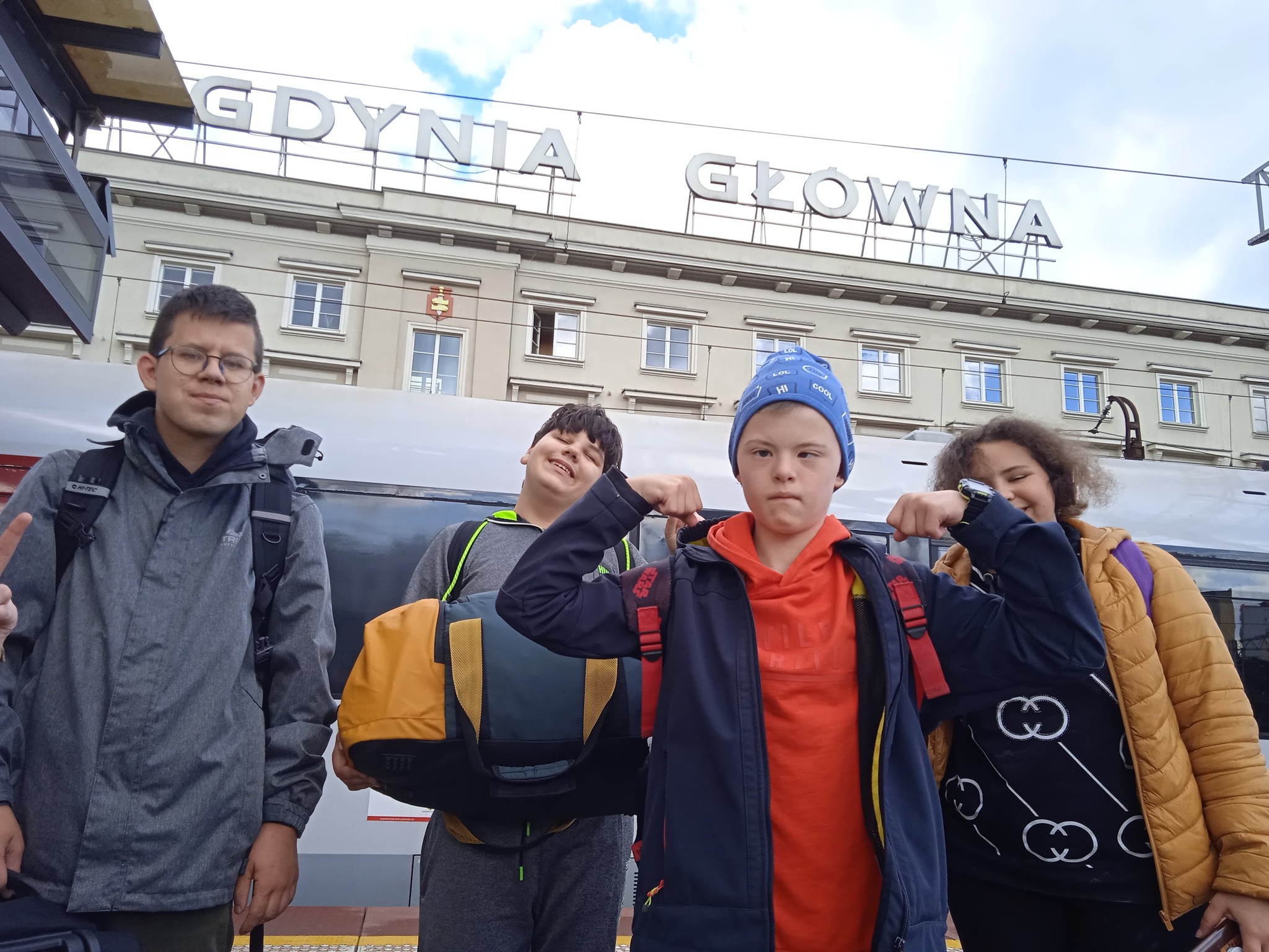 Grupa osób stoi przed budynkiem