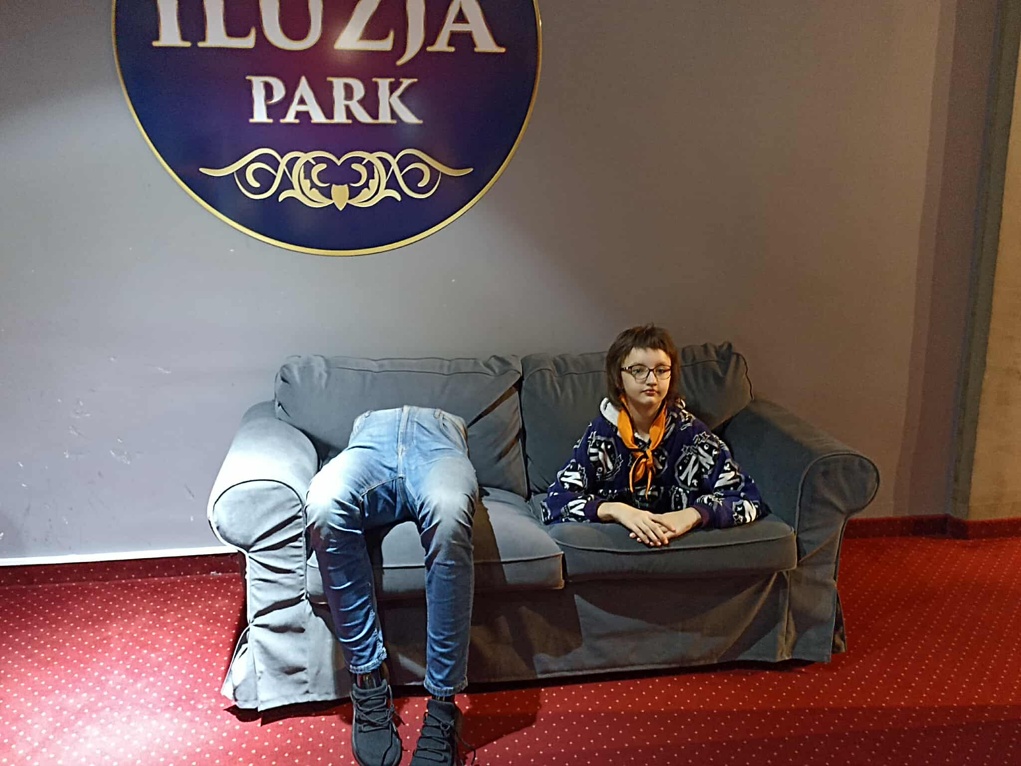 Na obrazku widać: osobę, kanapę, napisy