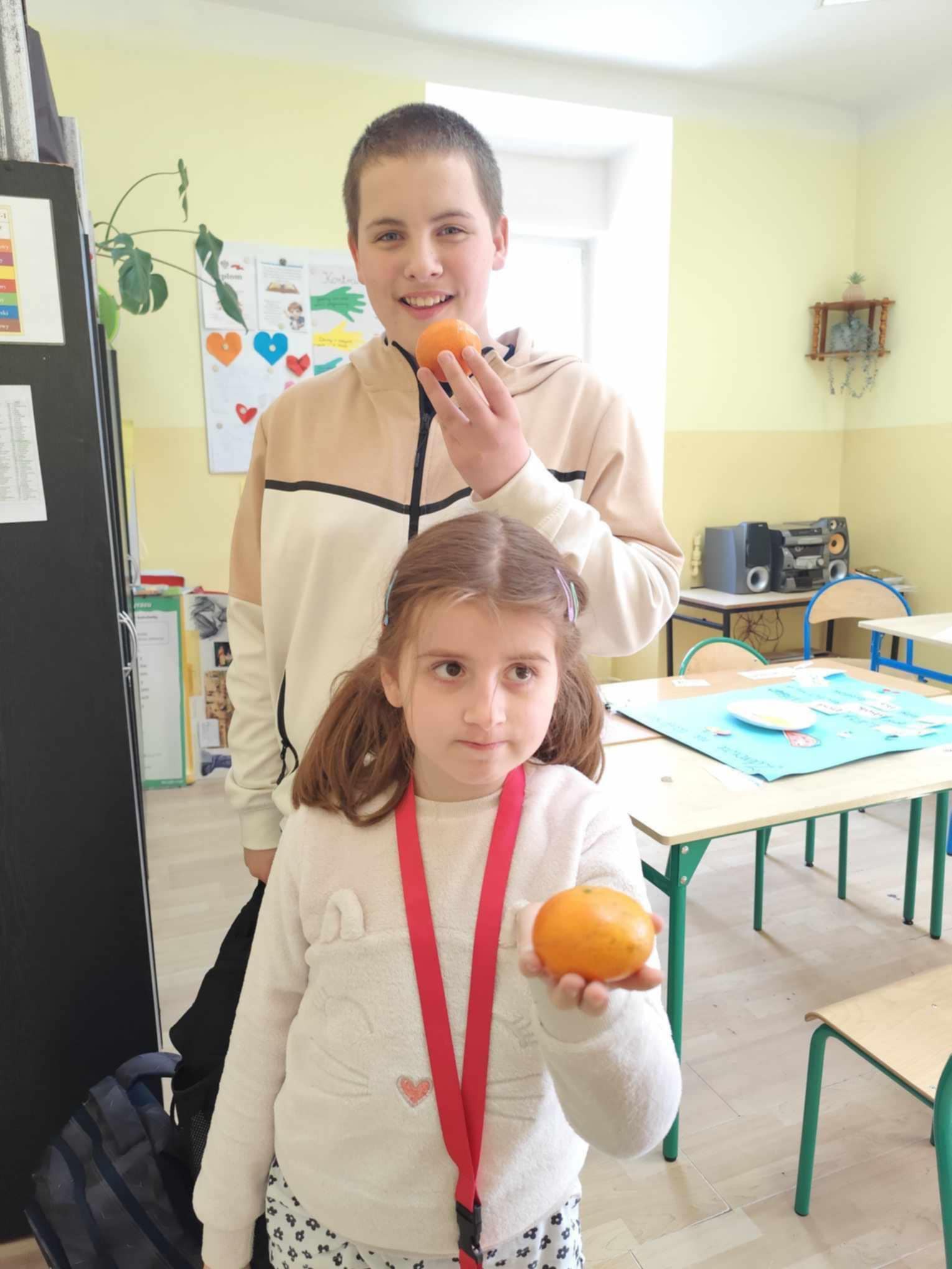 Na obrazku widać : stół, 2 osoby, ławki