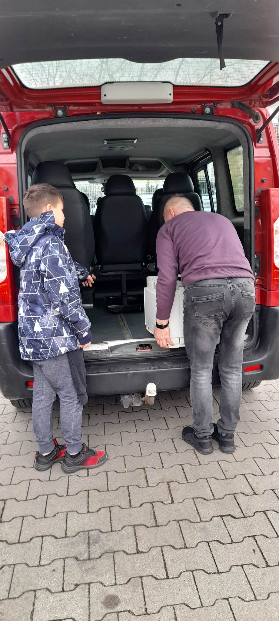 Na tle samochodu stoją dwie osoby
