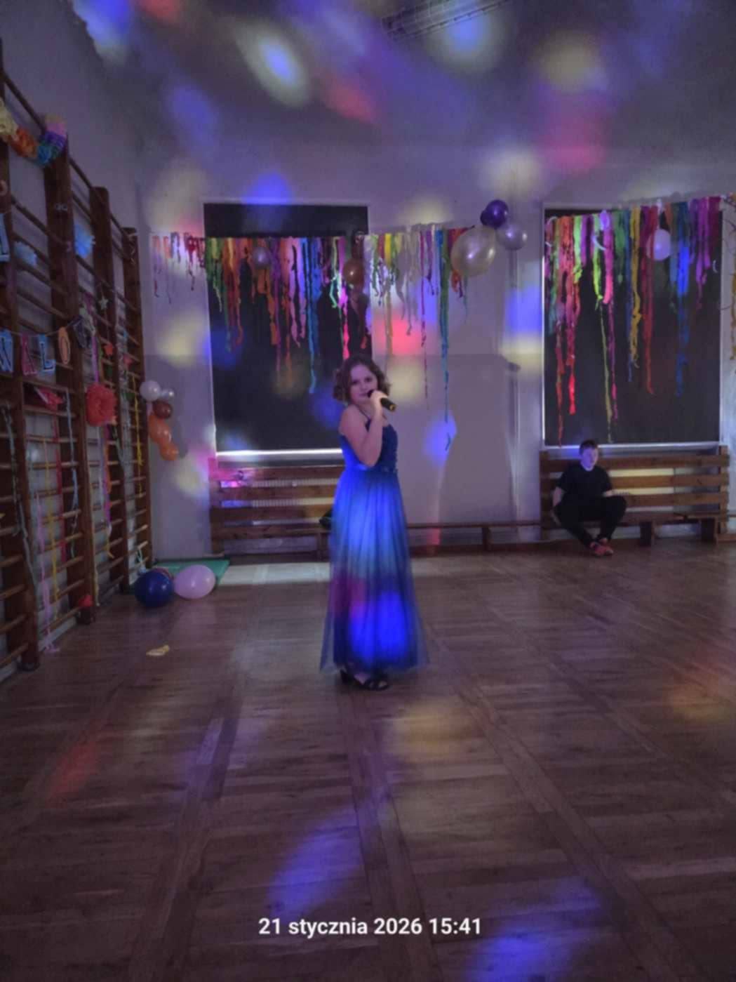 Na obrazku widać: osobę , kolorowe światła na suficie, podłogę. 