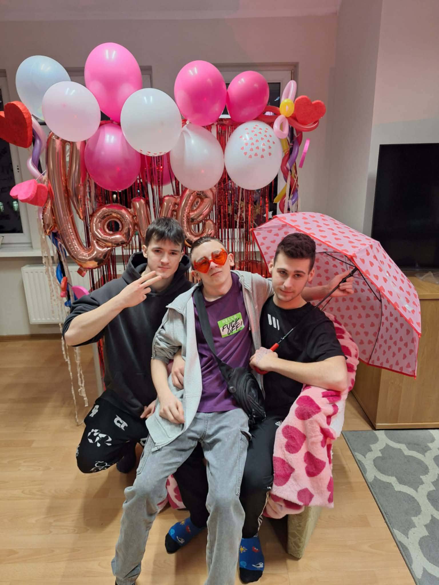 Na obrazku widać: grupę osób, balony, parasolkę. 