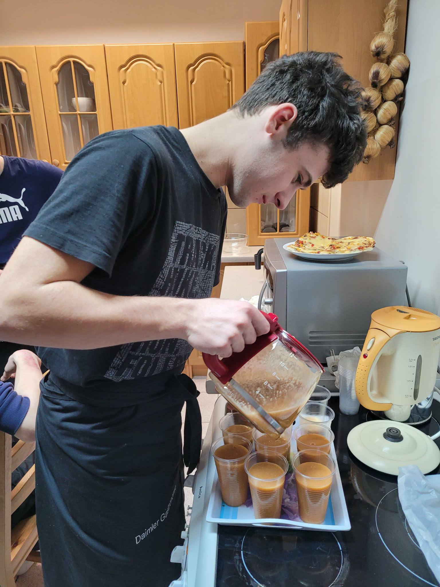 Na obrazku widac: osobę, szklanki z sokiem, szafki.